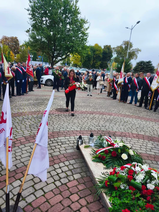 Znicze i kwiaty pod pomnikiem ks. Popiełuszki